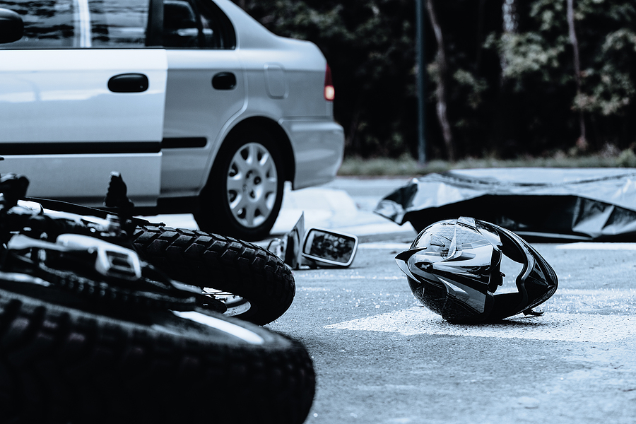 Helmet and motorcycle on the street after a crash.