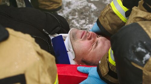 Firefighters lifting injured man. Rescue after car crash accident. If you've been injured in a car accident that wasn't your fault in Perrysburg, Ohio, contact Arthur Law Firm