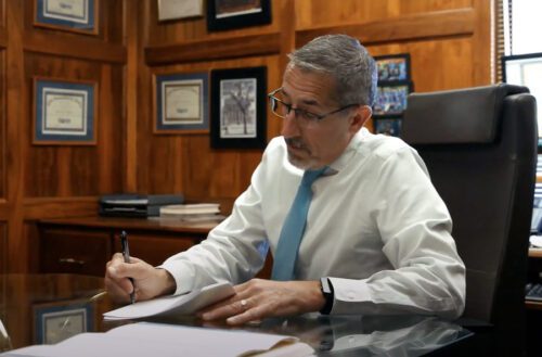 personal injury attorney Dan Michele with Arthur Law Firm sits at his desk reviewing an injury claim