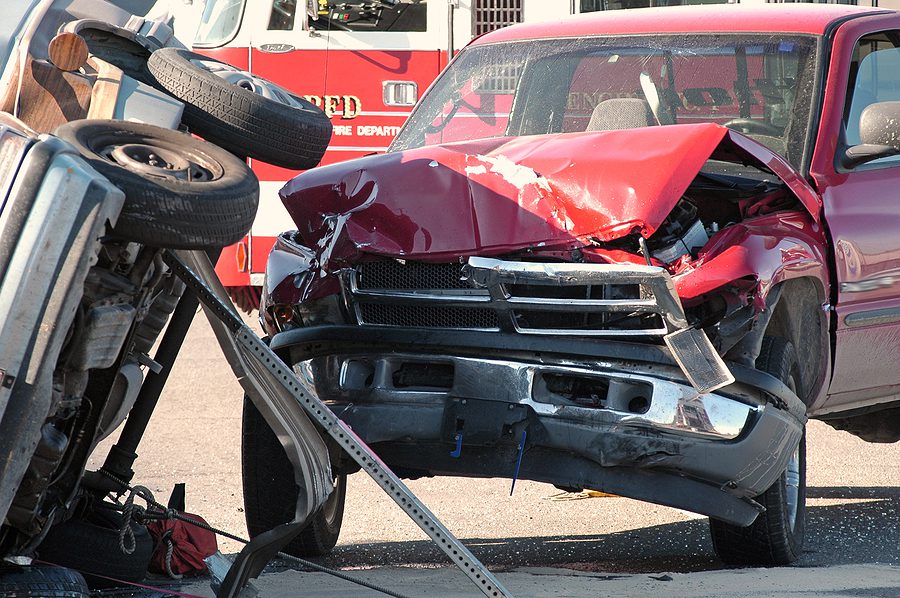 two car accident between a car and a truck, car is rolled over