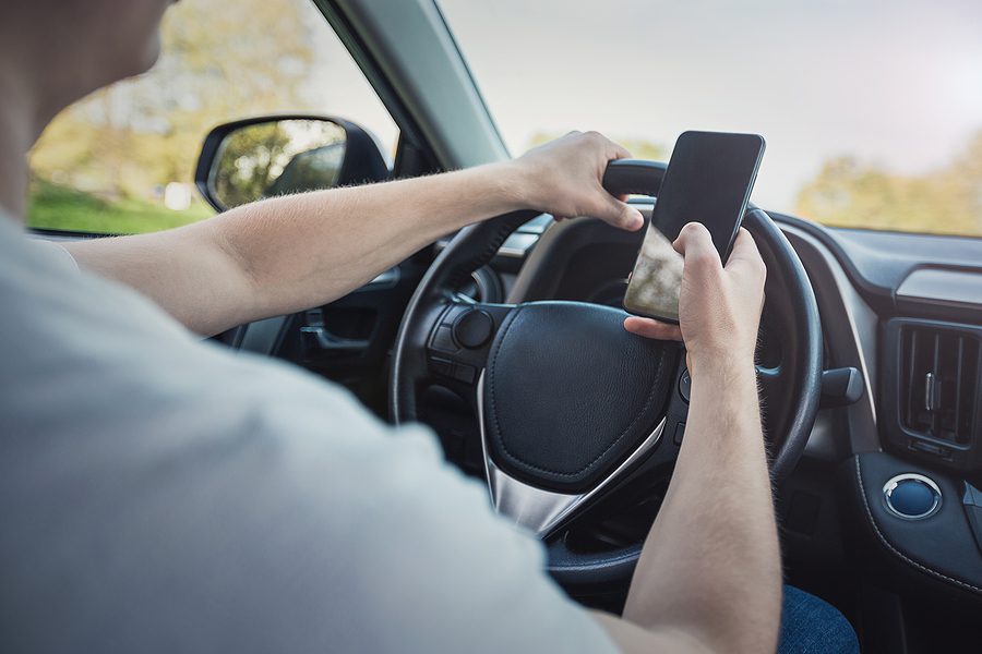 Man texting while driving a car.