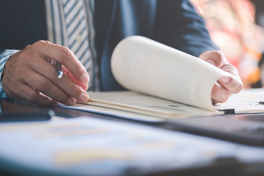 business man lawyer wearing a suit reviewing documents from a client
