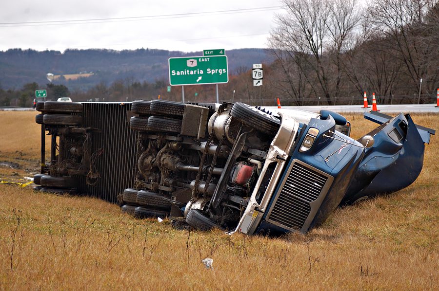tractor trailer roll over accident on the side of a highway