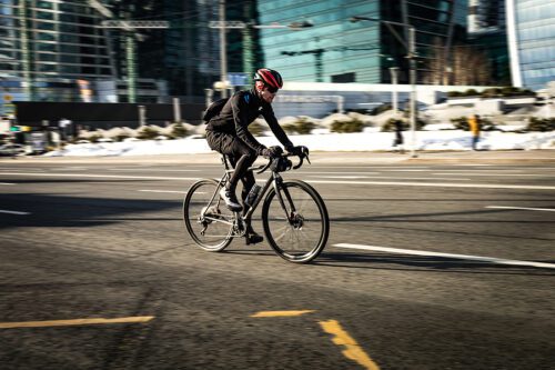 Man riding a bicycle on the urban highway on high speed. Bicycle rider in the city in motion blur. 