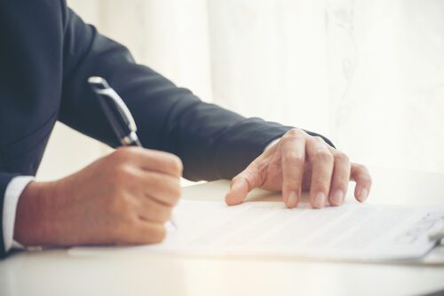 An attorney signing legal documents with a client that was in a serious car accident.