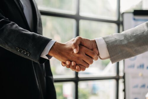 Two confident business man shaking hands during a meeting in the office, success, dealing, greeting and partner