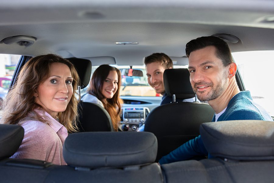 Group of smiling people inside a ride share car. 