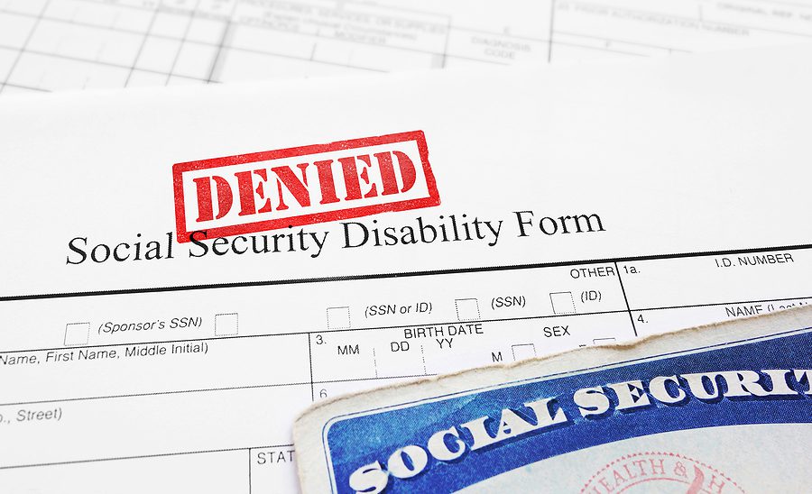 Close up of a social security disability form with the word "denied" stamped on it. 