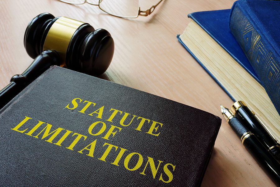 A blue book with "Statute of Limitations" written in yellow lettering with a gavel next to it.