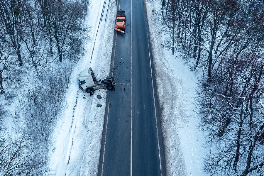 Aerial view of a truck accident on a snowy, icy road in the winter. 