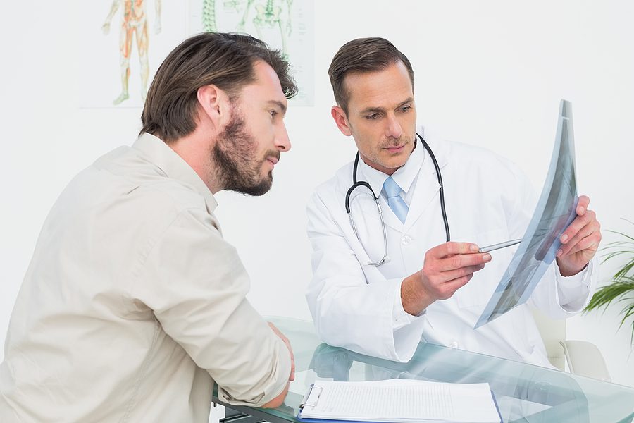 Male patient talking to a male doctor about the results of his spinal x-ray. 