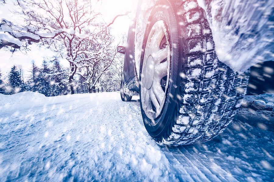 Close up of car tires on a winter road covered with snow. 