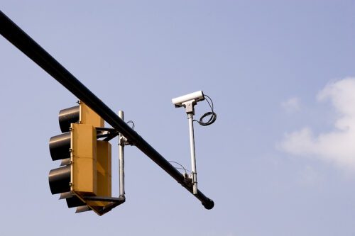 Red light camera mounted on a city traffic light. 