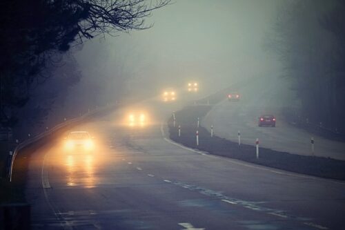 Cars driving in foggy, bad weather. 