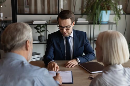 Male attorney meeting with an older couple to discuss their case.