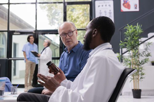 Senior male talking to his male physician about his condition and medication.