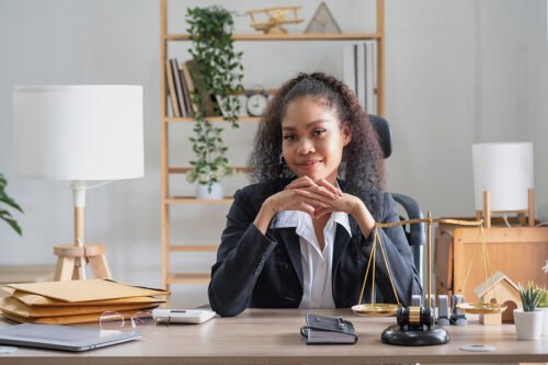 Friendly, approachable female attorney, sitting at her desk. 