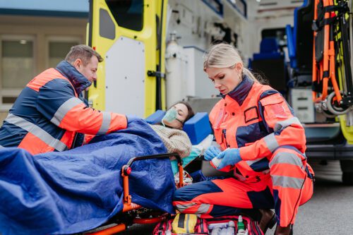 Paramedics loading a female car accident victim into an ambulance