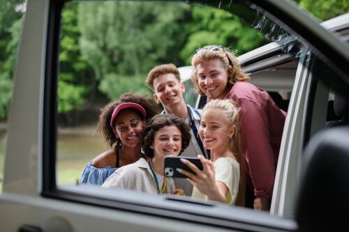 A group of teenagers taking a selfie while on a summer day trip 