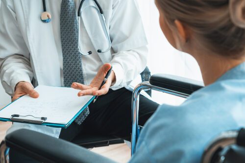 Closeup of a female patient talking to a doctor about her injuries. 
